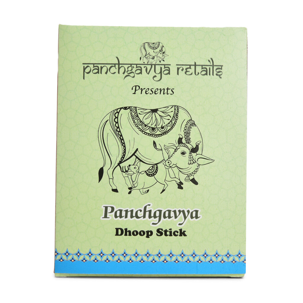 Box of Panchgavya Dhoop Stick placed on a wooden platform in a natural outdoor setting with flowers and mountains in the background. Ingredients include Gomay Powder, Dhuna, Van Aushadhi, and Sugandhit Tel (1%).